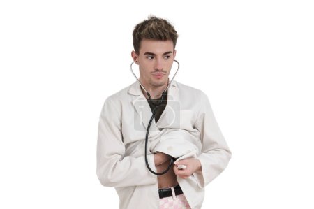 Foto de Joven médico caucásico escucha su corazón con un estetoscopio, aislado sobre fondo blanco. - Imagen libre de derechos