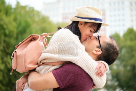 Multiracial couple of tourists kissing and enjoying travel together. Sightseeing in Madrid, Spain.