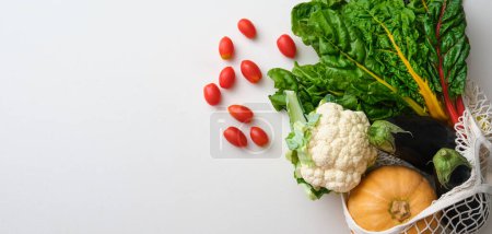 Photo for Bunch of rainbow swiss chard, cauliflower, tomato, squash, eggplant on beige stone table. Top view of fresh vegetables. - Royalty Free Image