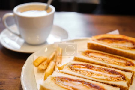 Foto de Katsu sando sándwich japonés con chuleta de cerdo empanada, col y salsa tonkatsu en una cafetería. - Imagen libre de derechos