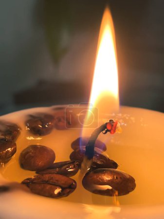 Foto de Candle glow in daylight. Wax contains coffee beans. - Imagen libre de derechos