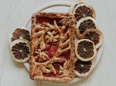 Foto de Homemade pie with jam, in the style of autumn comfort. A dried orange is laid out around the pie. - Imagen libre de derechos