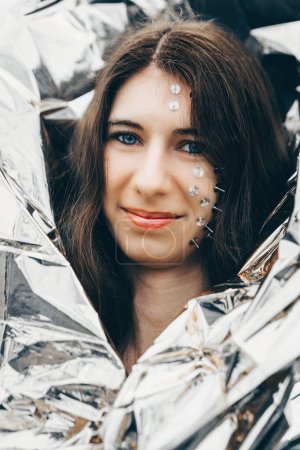 a woman as a fantasy portrait with tacks in her face and a silver foil