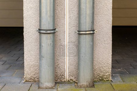 two rain downpipes on a house wall in the city
