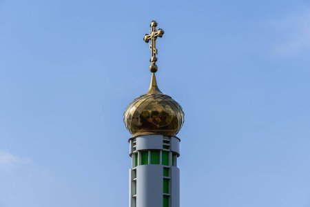 Photo for Tower with large golden dome and cross against blue sky. Place religion of orthodox christian for prayer in modern city. Monastyrsky island with church of saint Nicholas in Dnipro Ukraine. Bottom view. - Royalty Free Image