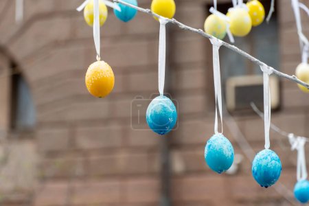 Photo for Colorful handmade egges for easter in branches outdoor. Decorating trees with hanging eastereggs in city street. Tradition holiday on christianity religion. Symbol of resurrection to new life. - Royalty Free Image