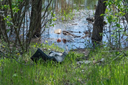 Müllhalde im Wald im Fluss verstreut Plastikmüll im See nach einem Picknick. Menschen werfen illegal Müll. Weltökologieproblem des Umweltschutzes. Müllhaufen in der Natur.