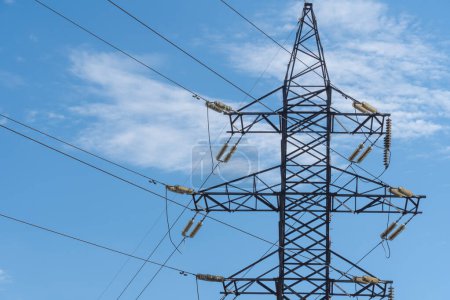 Electricity transmission towers and power lines in blue sky. Detail high voltage pole. Energy concept of industry. Communications and power supply. Crisis and problems in energy sector. Infrastructure