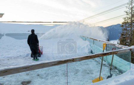 Foto de Vancouver, Canada - December 16,2022: A worker is removing snow from the observation deck at the Peak of Vancouver(Grouse Mountain Ski Resort) - Imagen libre de derechos
