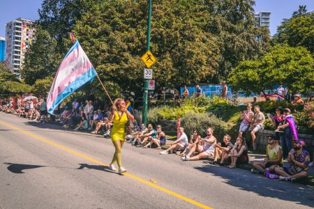Foto de Vancouver, Canadá - 31 de julio de 2022: La gente camina por la calle Pacific con una bandera del arco iris durante el Desfile del Orgullo - Imagen libre de derechos