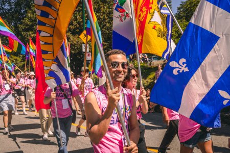 Foto de Vancouver, Canadá - 31 de julio de 2022: La gente camina por la calle Pacific con una bandera del arco iris durante el Desfile del Orgullo - Imagen libre de derechos