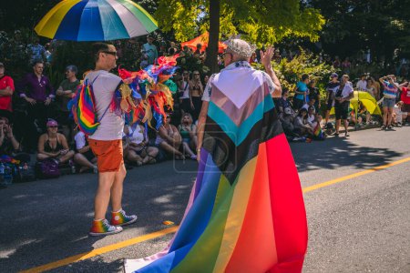 Foto de Vancouver, Canadá - 31 de julio de 2022: Durante el Desfile del Orgullo, un hombre con una corona y una capa de arco iris camina por Pacific Street - Imagen libre de derechos
