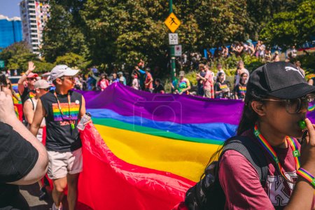 Foto de Vancouver, Canadá - 31 de julio de 2022: La gente camina por Pacific Street con una enorme bandera arcoíris durante el Desfile del Orgullo - Imagen libre de derechos