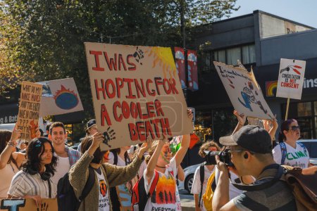 Photo for Vancouver, Canada - September 15,2023: Young activists with a sign: 'I was hoping for a cooler death,' walking down Cambie Street as part of the Global Climate Strike in Vancouver - Royalty Free Image