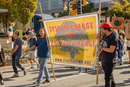 Foto de Vancouver, Canadá - 15 de septiembre de 2023: Activistas con un cartel: Cambio de sistema y no cambio climático caminando por Cambie Street como parte de la Huelga Climática Global en Vancouver - Imagen libre de derechos