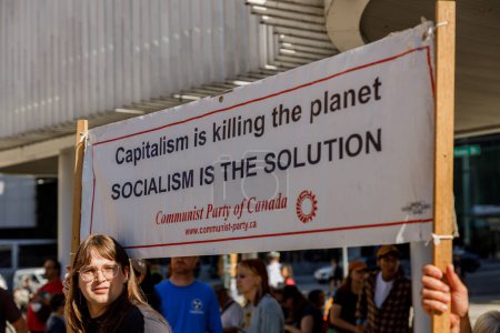 Foto de Vancouver, Canadá - 15 de septiembre de 2023: Activista con un cartel: El CAPITALISMO está matando al planeta, el SOCIALISMO es la solución como parte de la Huelga Climática Global en Vancouver - Imagen libre de derechos