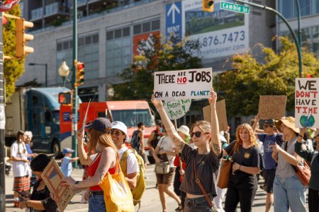 Foto de Vancouver, Canadá - 15 de septiembre de 2023: Jóvenes activistas con un cartel: NO hay empleos en un planeta muerto caminando por Cambie Street como parte de la Huelga Climática Global en Vancouver - Imagen libre de derechos