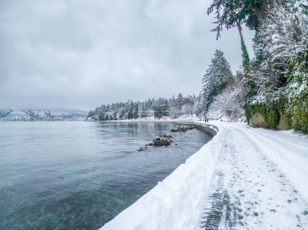 Vancouver's seawall at Third Beach covered in snow, displaying a serene white landscape after a heavy snowstorm