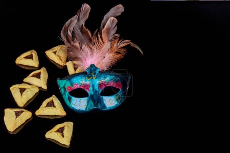 Ein Bild von Karnevalsmasken auf schwarzem Hintergrund stellt das jüdische Fest Purim dar..