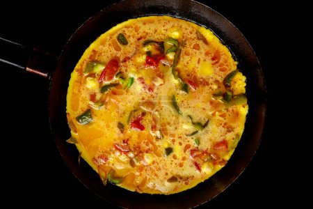 Eggs and vegetables are mixed together to make a vegetarian omelet.