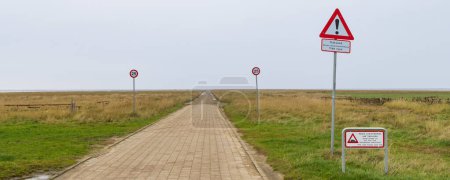Téléchargez les photos : Mando, Denmark - Novemebr 15, 2022: Stop and warning signs at dirt road to island Mando dangerous while this road floods twice per day during high water tide. - en image libre de droit