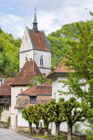 Téléchargez les photos : Paysage urbain avec église et platanes dans le pittoresque village Saint-Ursanne dans le canton du Jura quartier Porrentruy en Suisse - en image libre de droit