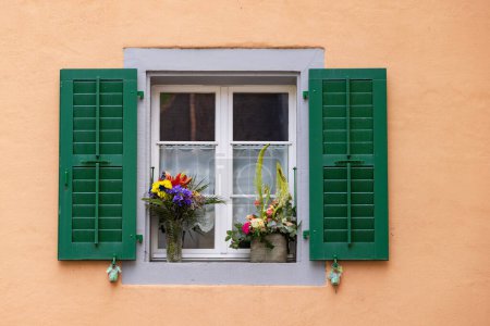 Téléchargez les photos : Petite fenêtre avec pots de fleurs dans village pittoresque Saint-Ursanne dans le canton du Jura quartier Porrentruy en Suisse - en image libre de droit