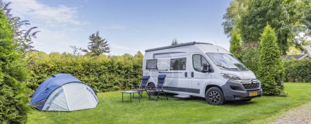 Téléchargez les photos : Camping-car blanc et petite tente bleue au camping - en image libre de droit