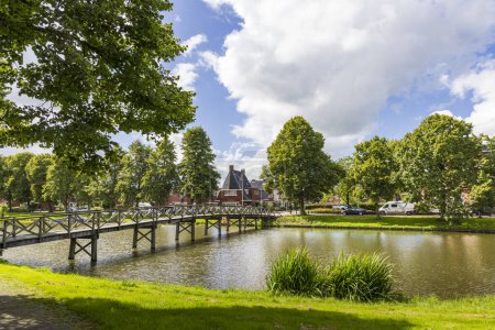 Téléchargez les photos : Delfzijl, Pays-Bas - 8 août 2023 : Paysage urbain de Delfzijl avec pont traversant l'étang jusqu'à la route Buitensingel dans la province de Groningue aux Pays-Bas - en image libre de droit