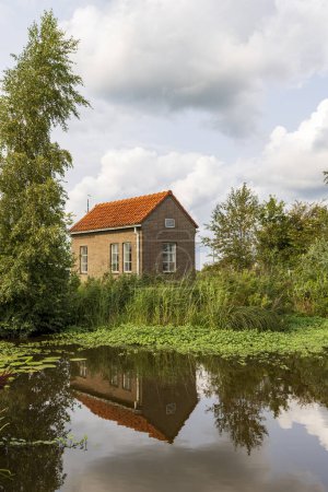 Photo for Tiny brick house along lake called Leekstermeer municipality Westerkwartier in Groningen province The Netherlands - Royalty Free Image