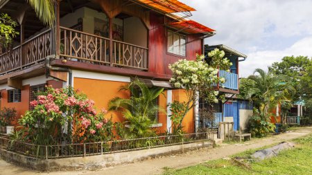 Colorful orange house and flower garden in El Castillo village along the San Juan river in Nicaragua
