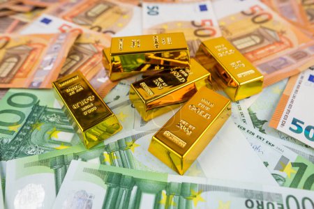 Euro banknotes and gold bars. Gold bars on money