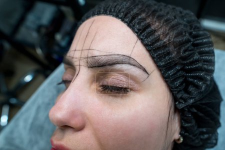 Photo for Woman's eyebrows with guide lines around the eyebrows to get the exact measurements for the permanent eyebrow makeup procedure. - Royalty Free Image