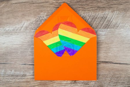 Téléchargez les photos : Enveloppe orange et deux coeurs aux couleurs arc-en-ciel. LGBT. Amour, droits de l'homme, tolérance. - en image libre de droit