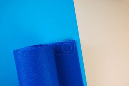 Téléchargez les photos : Gros plan de tapis roulé de yoga de couleur bleue, vue de dessus, espace de copie, mode de vie sain, sport et concept d'exercice - en image libre de droit