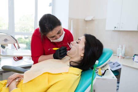 El dentista coloca carillas dentales en el paciente. El proceso de instalación.Odontología, Diseño de la sonrisa, Dientes blancos.Restauración de dientes.