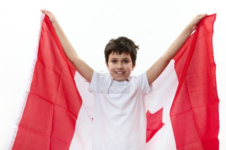 Foto de Feliz ciudadano canadiense, un adolescente con camiseta casual y vaqueros azules, llevando una bandera de Canadá, celebrando el Día de la Independencia el 1 de julio. Concepto de libertad, libertad y ciudadanía - Imagen libre de derechos