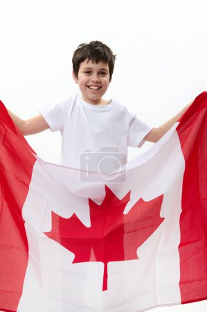 Foto de Adolescente estadounidense lleva bandera canadiense, celebra el Día de la Independencia de Canadá, el 1 de julio, aislado sobre fondo blanco, con espacio publicitario para el texto. Ciudadanía Patriotismo Concepto de Emigración - Imagen libre de derechos
