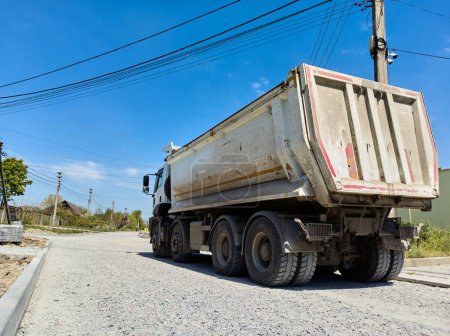 Photo for Rear view. Still life with a truck carrying construction sand or concrete. The concept of reloading on the roads and renting a dump truck for work, road repair. Copy advertising space. - Royalty Free Image