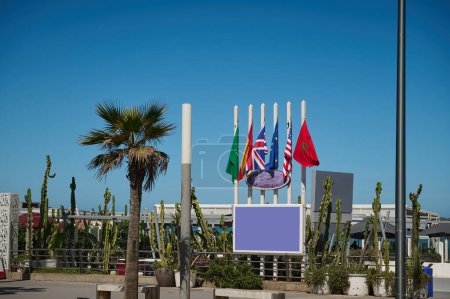 Photo for Background with flags of different countries on the promenade. Moroccan, Spanish, European Union, USA and Great Britain flags over blue sky background - Royalty Free Image
