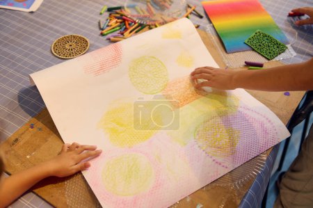 Foto de Primer plano de las manos de los niños dibujando con lápices de colores pastel en papel de cartón, aprendiendo pintura durante la clase de arte en un taller creativo. Gente. Pasatiempo creativo para niños. Educación - Imagen libre de derechos