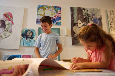 Foto de Adorables niños de edad elemental se centraron en el aprendizaje de bellas artes en el taller de arte creativo, dibujo, pintura imágenes - Imagen libre de derechos