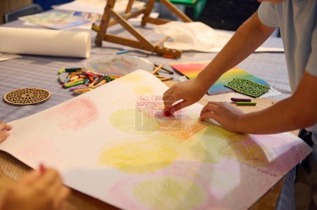 Foto de Vista de cerca colegiala dibujo en papel con lápices de colores pastel, creando un fondo para más durante la clase de arte en la escuela de bellas artes o galería - Imagen libre de derechos