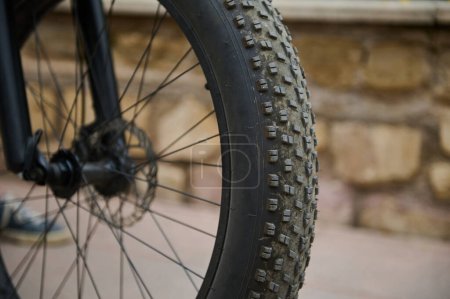 Shallow tread of a bicycle tubeless tire. Details on tubeless tire of an electric motor bike, mountain bike. Cropped view of electric bike bicycle wheel with spokes. Copy advertising space
