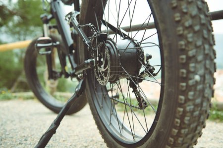Foto de Detalles de una rueda de neumático de bicicleta de montaña eléctrica sin tubo, de pie en el sendero de la carretera. Vista desde abajo. Bajo ángulo de visión. Enfoque selectivo - Imagen libre de derechos