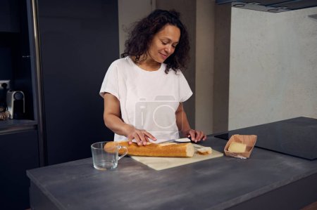 Frau schneidet Brot, bereitet morgens gesunde Sandwiches für das Frühstück in der heimischen Küche zu