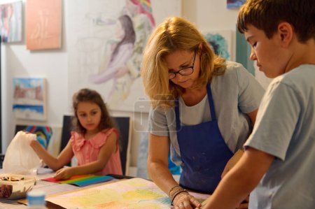 Kinder haben Kunstunterricht, Zeichnen, Malen mit dem Lehrer in der Werkstatt. Kunstwerke schaffen, Techniken lernen und Spaß haben.