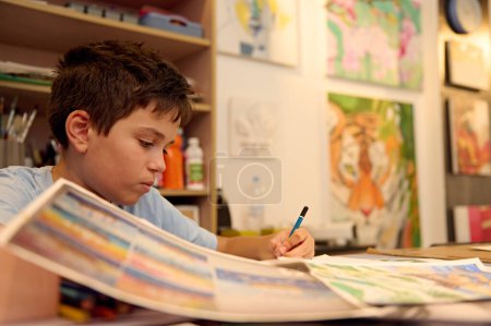 Kinder haben Kunstunterricht, Zeichnen, Malen mit dem Lehrer in der Werkstatt. Junge konzentriert sich intensiv auf sein Kunstwerk.