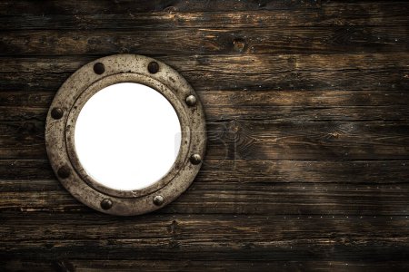 Close-up of an old rusty closed empty porthole window. Old rich wood grain texture background with knots.