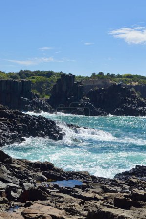 Des vagues se brisent sur des formations rocheuses à Bombo sur la côte sud de la NSW, en Australie
